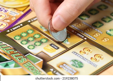 Coquitlam BC Canada - June 15, 2014 : Woman scratching lottery ticket called Monopoly. It's published by BC Lottery Corporation has provided government sanctioned lottery games. 