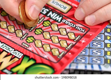 Coquitlam BC Canada - March 26, 2014 : Scratching lottery tickets. The British Columbia Lottery Corporation has provided government sanctioned lottery games in British Columbia since 1985. 