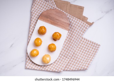 Coquitos Coconut Balls With Caramel On Marble Board On Squared Rag On White Marble