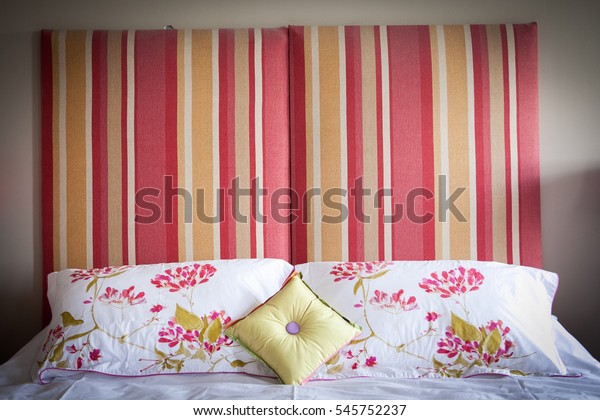 Coral and orange striped headboard of master bed in luxurious French chateau castle