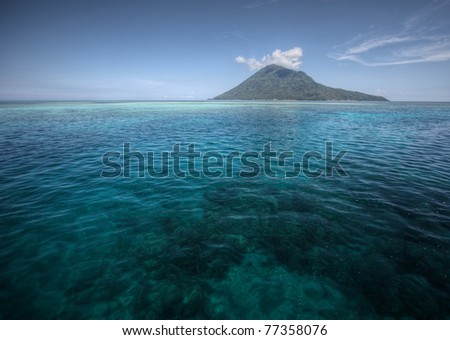 Coral reef transparent sea and white clouds. Bunaken island. indonesia