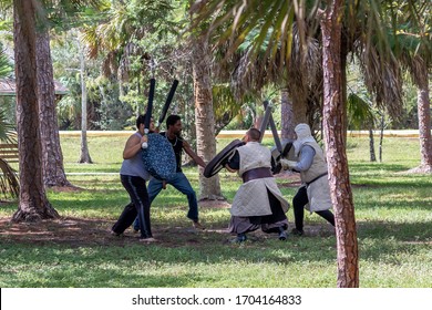 Coral Springs, Florida / USA - 10/6/2019: Grown Men Some In Costume With Fake Swords And Shields Practice Battling In Orchid Park For Renaissance Fair Festival. Live Action Role Play Aka LARPing