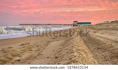 Coral sunset over the turquoise pier house at Avalon Pier in Kill Devil Hills, North Carolina.