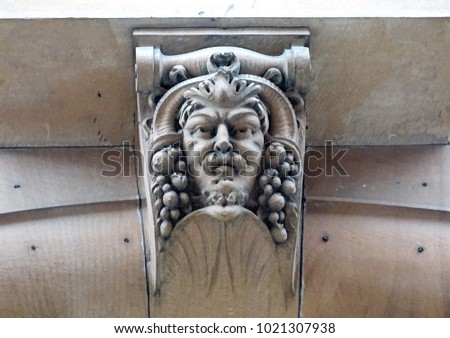 Corbel and keystone:  carved sandstone of male face with cornucopia headdress