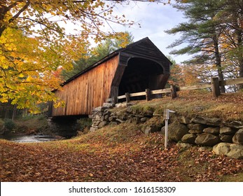 Corbin Covered Bridge in New Hampshire on a sunny autumn day.
