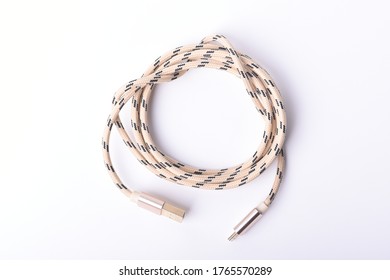 Cord, Wire For Electric Charging And Data Transfer To A Computer, Phone Or Tablet Shaped Like A Snake Twisted Into A Knot On A White Background