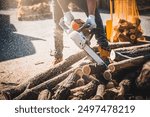 Cordless Chainsaw. Close-up of woodcutter sawing chain saw in motion, sawdust fly to sides. Chainsaw in motion.  Sawdust fly around. Firewood processing.