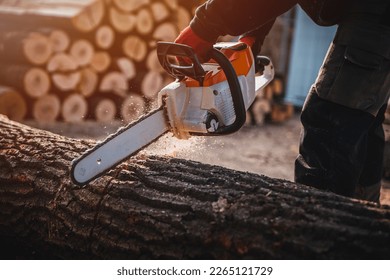 Cordless Chainsaw. Close-up of woodcutter sawing chain saw in motion, sawdust fly to sides. Chainsaw in motion. Hard wood working in forest. Sawdust fly around. Firewood processing. - Shutterstock ID 2265121729