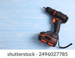 Cordless Drill Featuring Various Drill Bits Set Against a Vibrant Blue Background