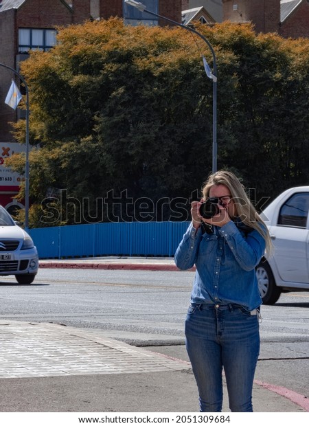 CORDOBA, ARGENTINA - Aug 25, 2021: A vertical\
shot of a female taking photo on the street on a sunny day in\
Cordoba, Argentina
