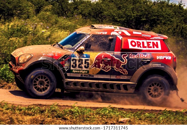 Cordoba, Argentina, Year 2016: Race car competing\
in Dakar Rally, Mini, Sponsor Redbull. Fast off road driving on\
dirty road. Pilot: Malysz\
Adam.