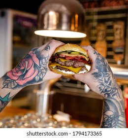 Cordoba Argentina, Year 2020.
Tattooed Man Eating Hamburger With His Hands