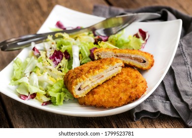 The Cordon Bleu, Cutlet Rolled Around Ham And Cheese, Then Breaded With Salad On A White Plate