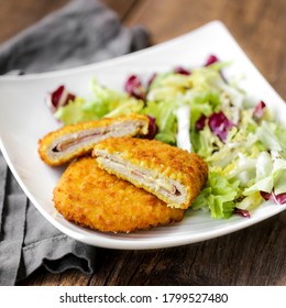 The Cordon Bleu, Cutlet Rolled Around Ham And Cheese, Then Breaded With Salad On A White Plate