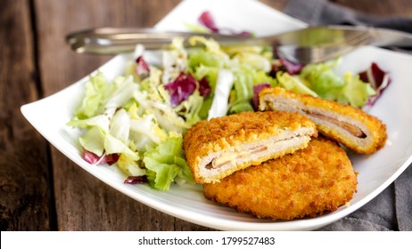 The Cordon Bleu, Cutlet Rolled Around Ham And Cheese, Then Breaded With Salad On A White Plate