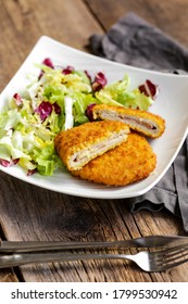 The Cordon Bleu, Cutlet Rolled Around Ham And Cheese, Then Breaded With Salad On A White Plate