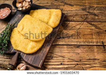 Cordon bleu meat cutlets with bread crumbs on a wooden board. wooden background. Top view. Copy space.