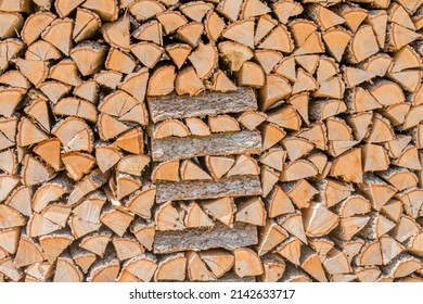 Cords Of Firewood Stacked In Dirt Lot In Countryside.