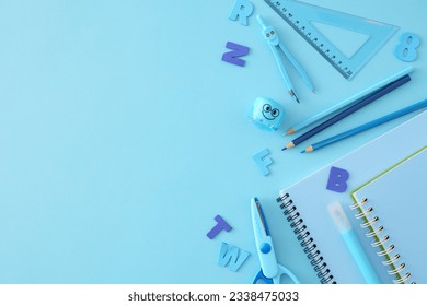 Core of learning idea. Top view composition of copybooks, marker, pencils, compass, sharpener, ruler, scissors, blue letters on light blue background with empty space for advert or text
