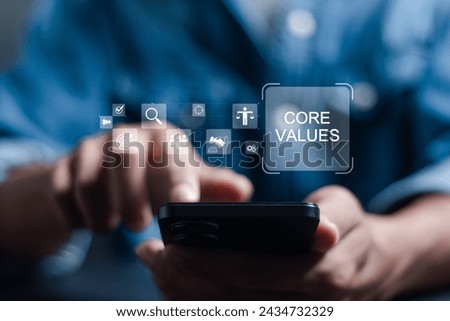 Core values responsibility ethics goals company concept. Person using smartphone with Core Values icons on virtual screen.