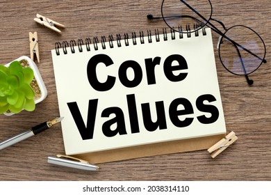 Core Values - text on white notepad paper on wood background - Shutterstock ID 2038314110