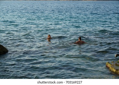 Corfu, Greece - AUGUST 2, 2017: Couple Swimming In The Sea At The Beach