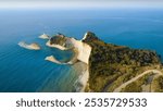 Corfu, Greece. High angle view of a coastline, showcasing the natural beauty of coastal and oceanic landforms. The landscape is complemented by mountains and a clear sky.