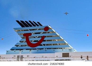 Corfu, Greece - June 2022: TUI Logo On The Funnel Of A Cruise Ship Operated By Marella Cruises, With A Holiday Jet Flying Overhead