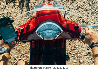 Corfu, Greece - September 2021. Man's Hands On Steering Wheel Of Red Vespa, Guy Driving Moped Or Scooter, Close-up View. Driver Rides Motor Bike. Handlebars Of Motorcycle.