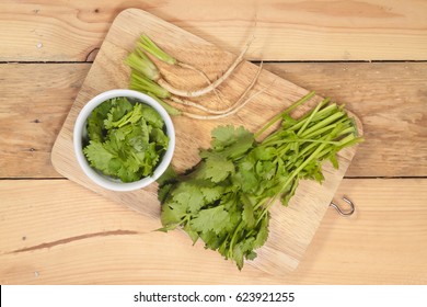 Coriander And Chopping Board On Wood Background