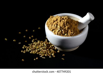 Coriander Powder And Seeds With Mortar And Pestle On Black Background.