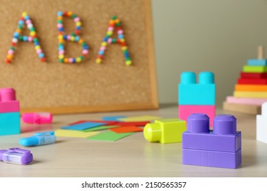 Cork board with abbreviation ABA (Applied behavior analysis) at table, focus on colorful blocks