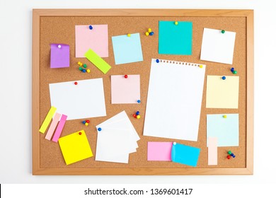 Cork board with several colorful blank notes with pins