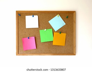 Cork Bulletin Board With Empty Pinned Paper Reminders On A White Wall