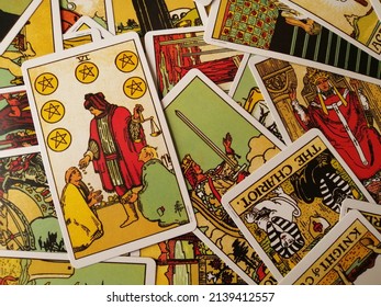 Cork, Ireland - 17 March 2022: Picture of the Six of Pentacles tarot card from the original Rider Waite tarot deck with mixed tarot cards in the background