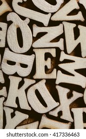 Corkboard Covered With Multiple Wooden Letters As A Background Composition.