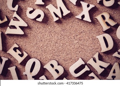 Corkboard Covered With Multiple Wooden Letters As A Background Composition.