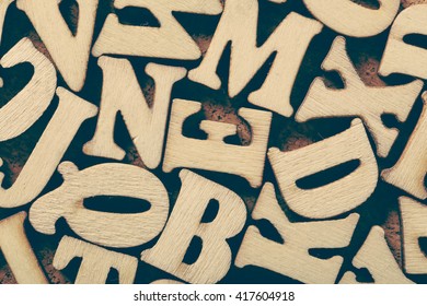 Corkboard Covered With Multiple Wooden Letters As A Background Composition.