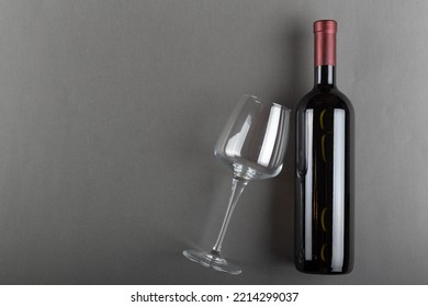 Corked Bottle Of Red Wine And Empty Wine Glass On Gray Background. Alcoholic Drink. Winemaking Concept. Space For Text. Top View.