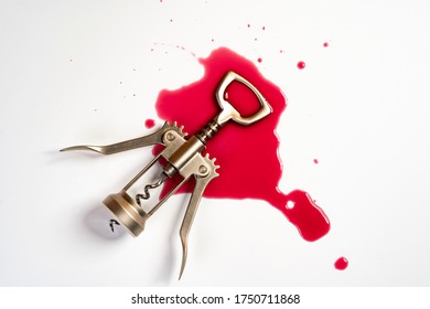 a corkscrew on a patch of wine on a white surface