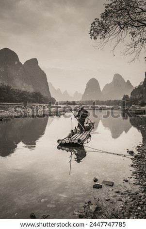 Cormorant fisherman and his bird on the Li River in Yangshuo, Guangxi, China. Sunset sky with copy space for text