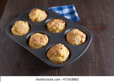 Corn Bread Muffins In Muffin Pan On Country Distressed Wood Table.