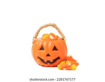 Corn candy in isolated white background Halloween concept  Bucket Halloween pumpkin Jack  o  lantern and candy corn for halloween celebration Pumpkin and scary smile his face Candy bucket 
