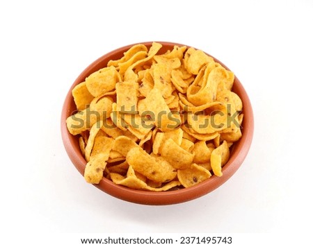Corn chips, barbecue flavored, in an earthenware  bowl on white background.