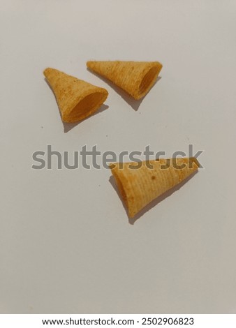 Corn cone pile isolated. Bugles chips, puffs with spices, crunchy puffed snacks, salty corn cones. Triangle shaped snack.