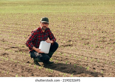 Corn Crop Protection Concept, Male Farmer Agronomist Holding Jerry Can Container Canister With Pesticide, Selective Focus