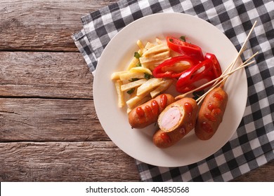 Corn Dog With Fries And Vegetables On A Plate Close-up On The Table. Horizontal Top View
