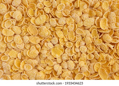 Corn flakes background. Cornflakes scattered on a table. Close up top view.