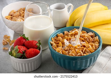 Corn flakes in the bowl with berries and milk on the table. - Powered by Shutterstock