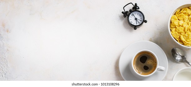 Corn flakes, coffee, alarm clock on a light background, breakfast. - Shutterstock ID 1013108296